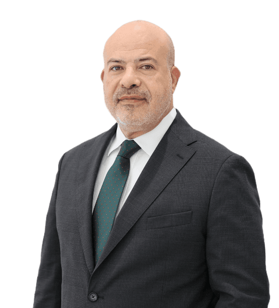 Bassem Meshaal, Design and Technical Director, Trojan Property Investment (TPI) - A professional man in a dark suit with a white shirt and green tie stands confidently against a plain background highlighting his business attire and formal presentation.