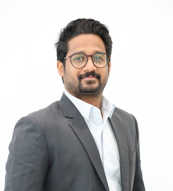 Nihas Ali, Senior Planning Engineer, Trojan Property Investment (TPI) - Professional man in a grey suit and glasses standing confidently with a light background, exuding a sense of expertise and authority in a business or corporate setting.